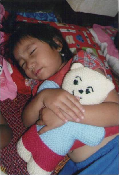 A child sleeps with a teddy bear