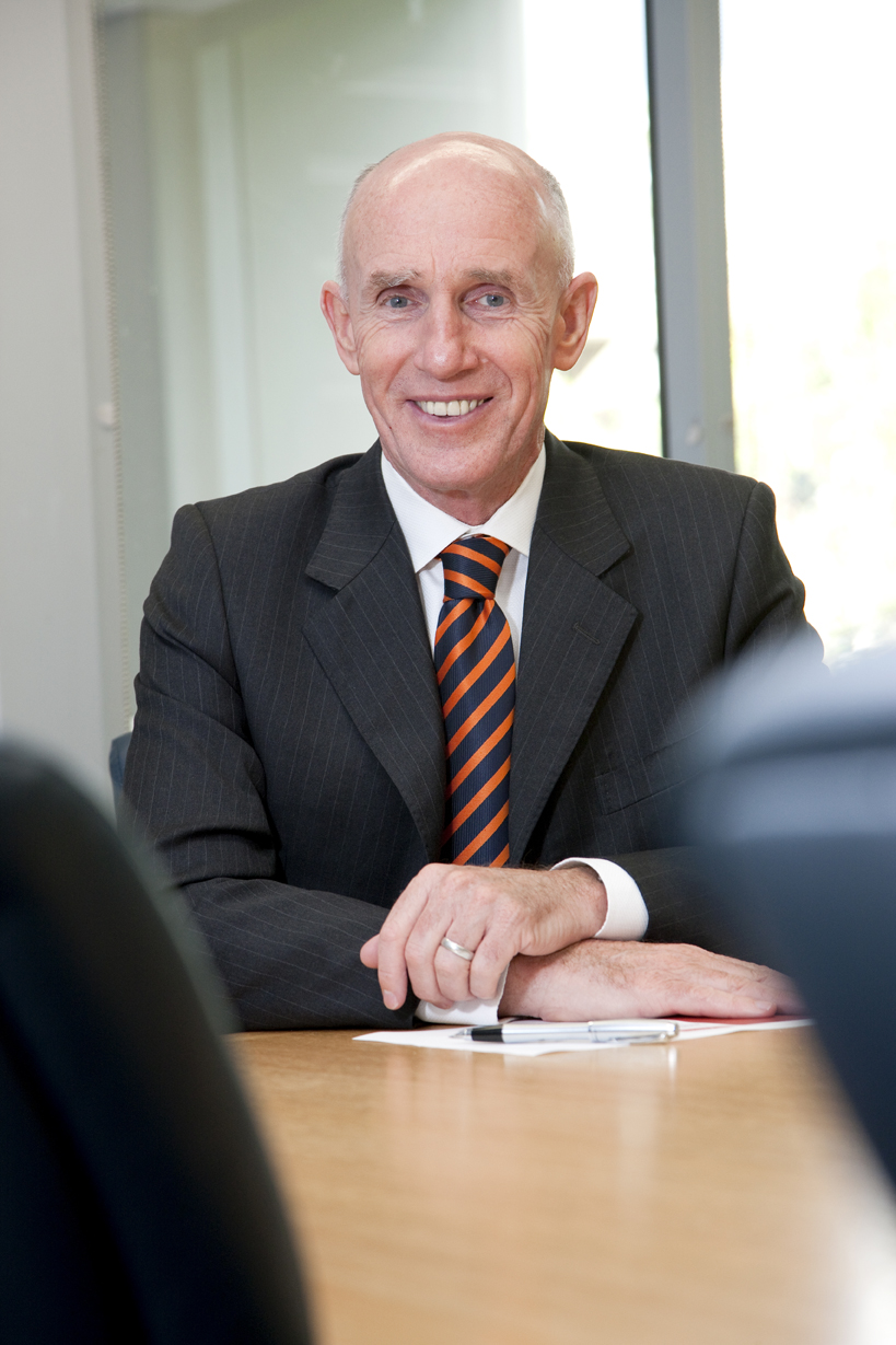 Professor Michael Powell, Pro Vice Chancellor (Business), sitting at top of board table.