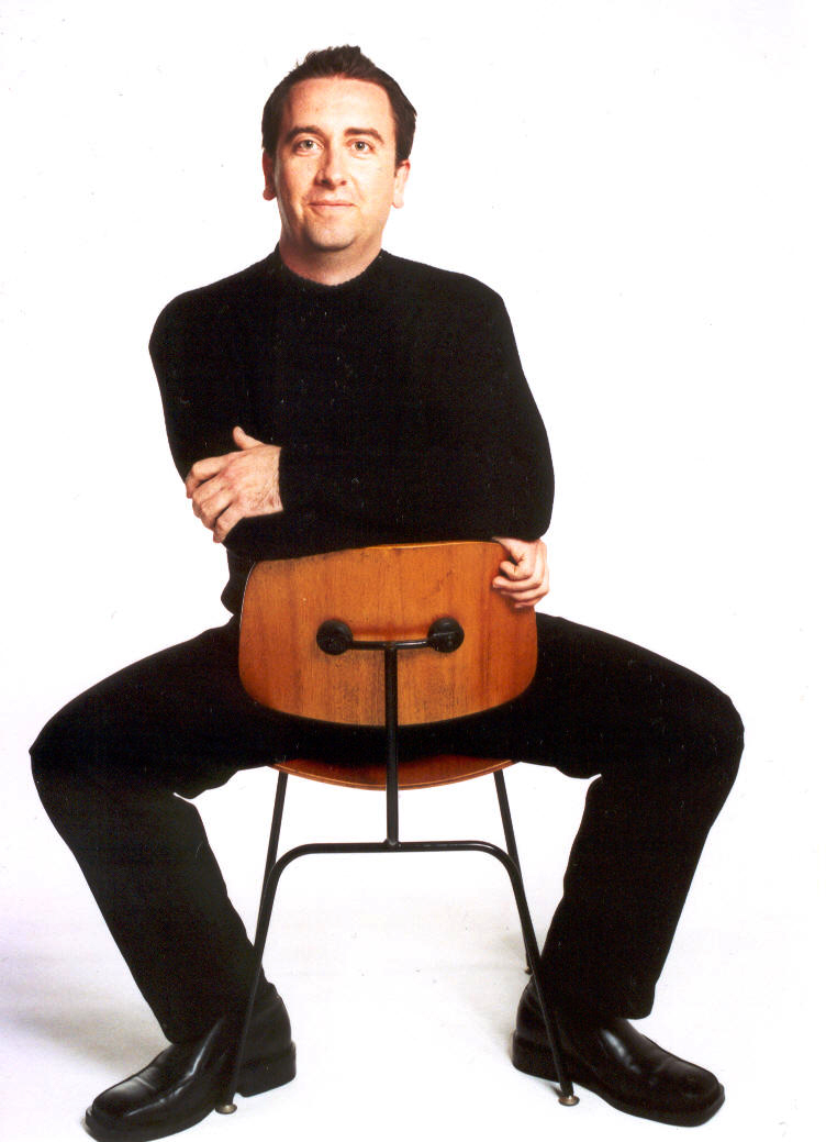 Gordon Hughes sits on chair, facing backwards