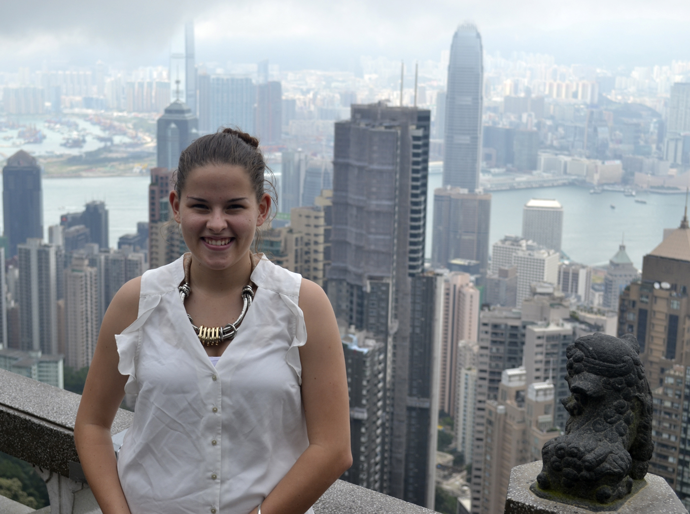 Griffith student Elise Giles on a rooftop lookout with Hong Kong city skyline in background