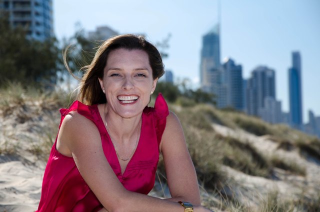 Sarah Gardiner, Griffith University, on beach with Gold Coast high rise skyline in background.