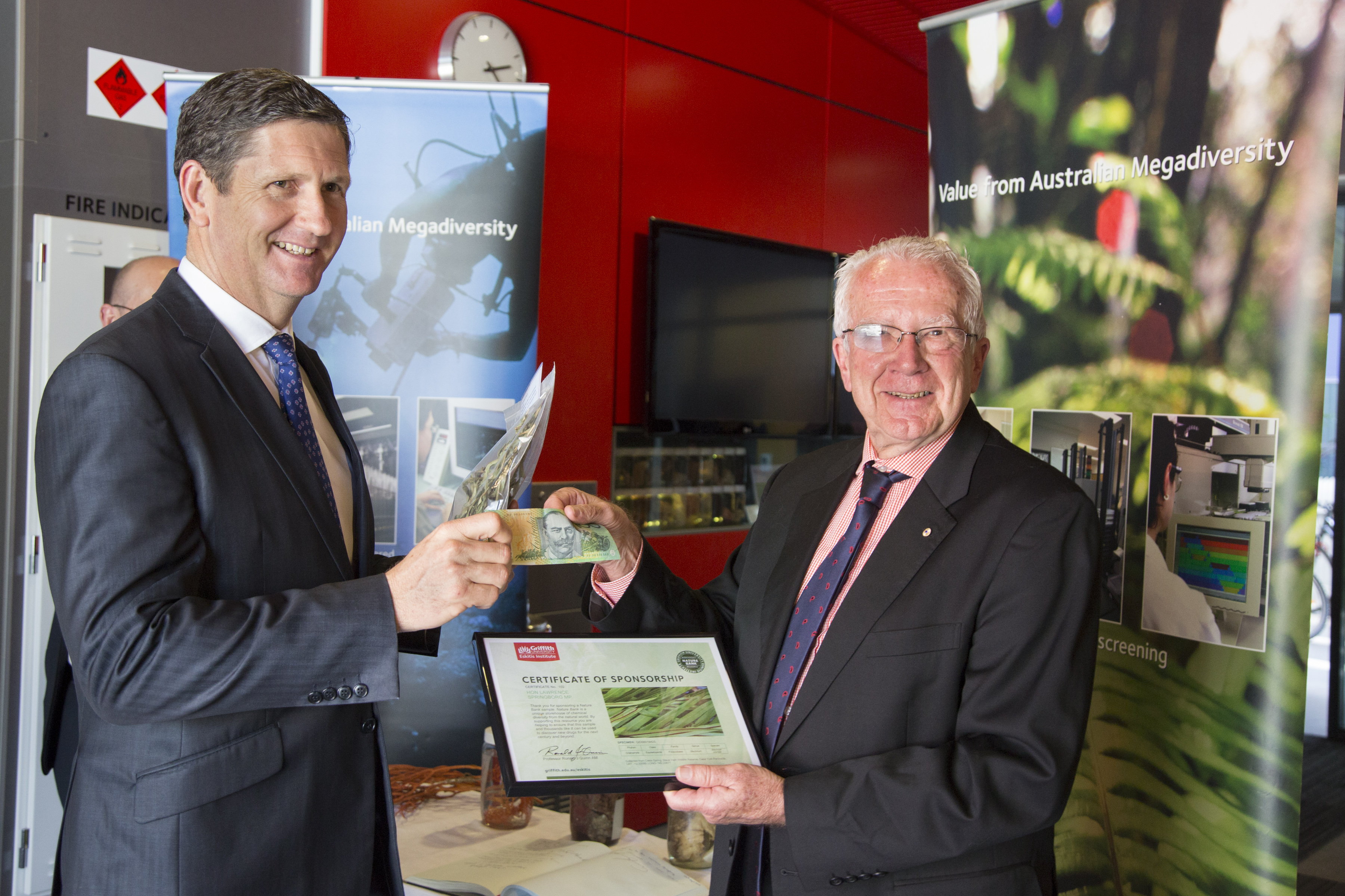 Queensland Health Minister Lawrence Springborg hands over $100 to Eskitis Director Professor Ronald Quinn to sponsor a sample and aid medical research