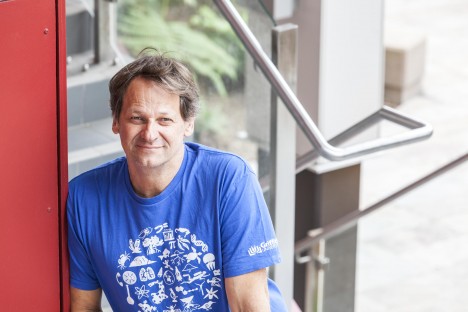 Dr Tim Stevens in blue t-shirt on stairway