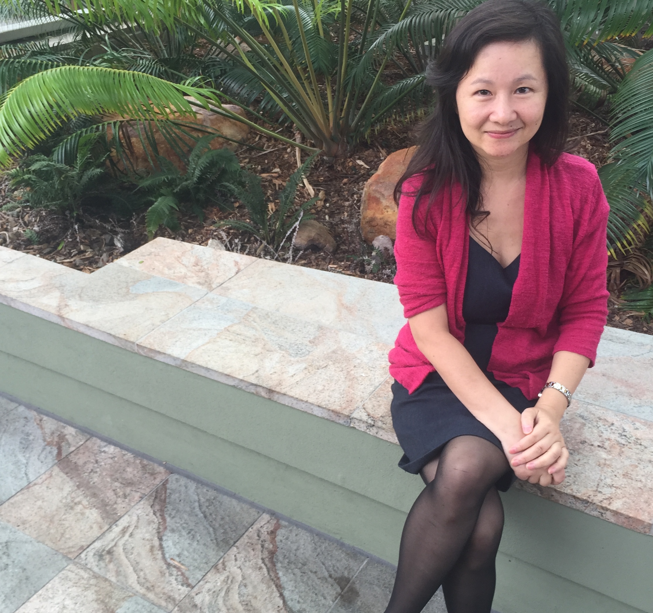 Dr Qin Li, from Griffith University's Queensland Micro- and Nanotechnology Centre, sitting and smiling on campus