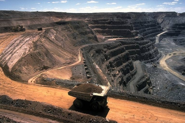 An overview image of a open mine with one huge truck in view.