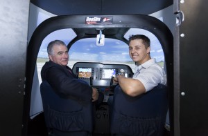 Vice Chancellor Professor Ian O'Connor in the pilot's seat of the new CAZ-80 flight simulator, alongside GeoSim Technologies technician-designer, Mr Chris du Plessis