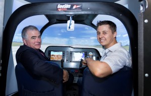 Vice Chancellor Professor Ian O'Connor in the pilot's seat of the new CAZ-80 flight simulator, alongside GeoSim Technologies' technician-designer Mr Chris du Plessis