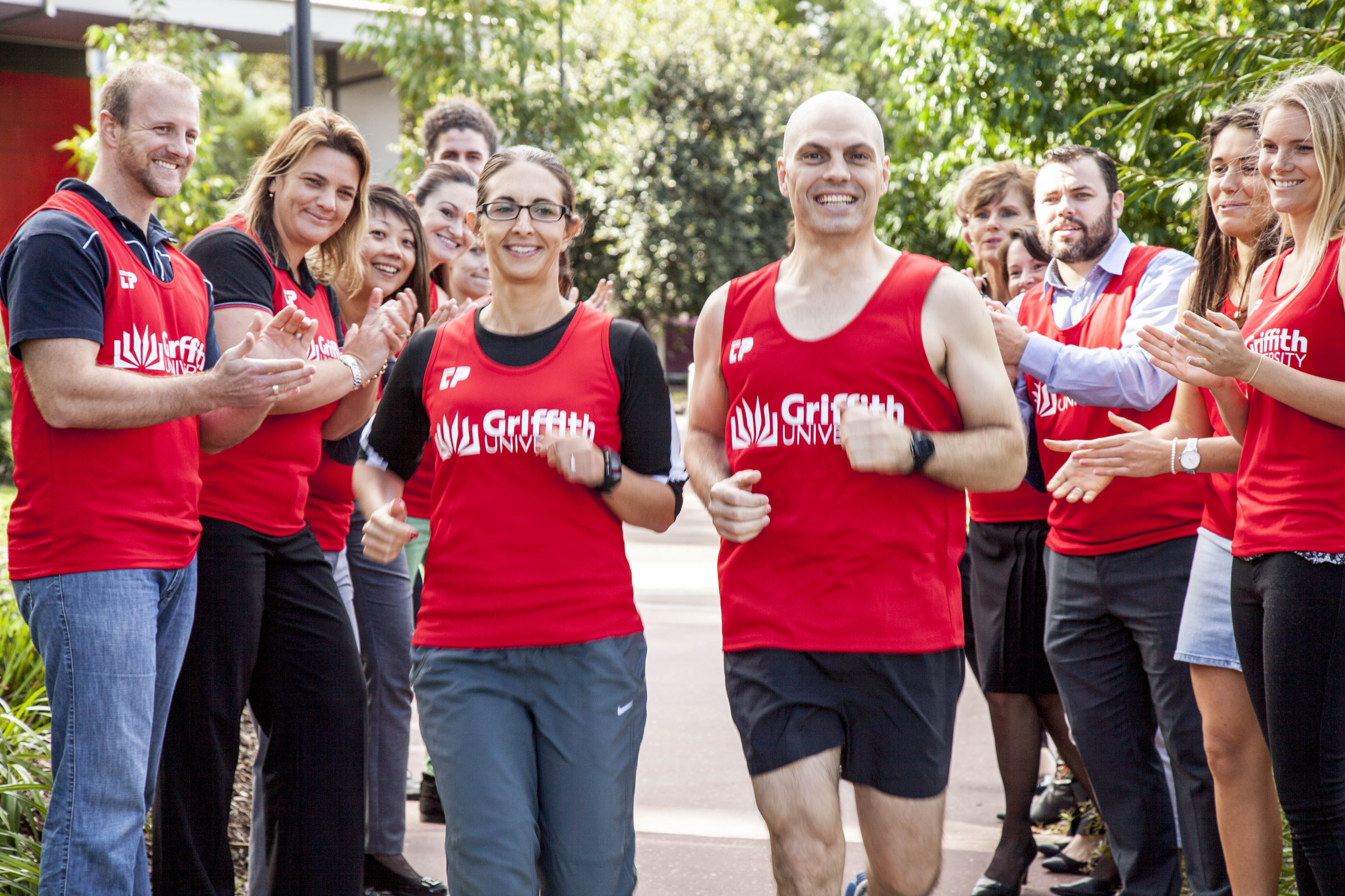 Griffith staff Lara Herrero and Andrew Williams are cheered on by fellow competitors ready to participate in the Gold Coast Airport Marathon.