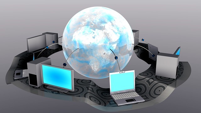 A globe surrounded by five laptops