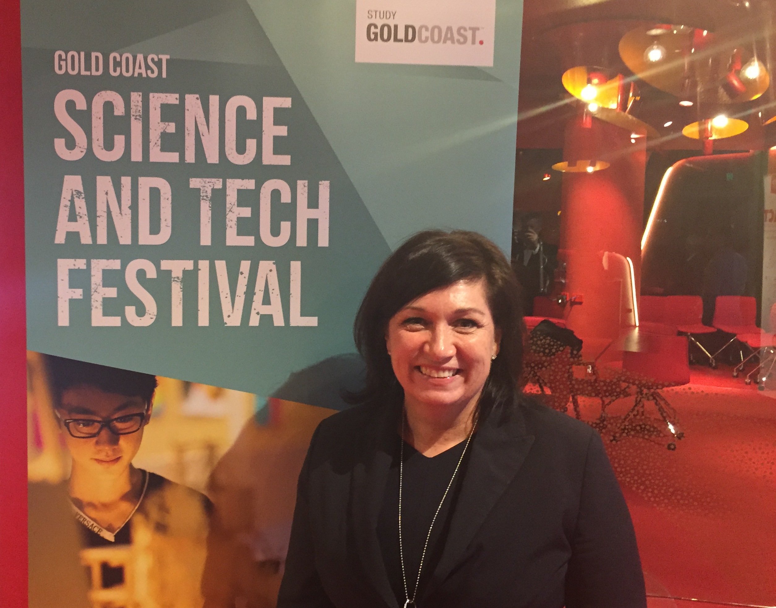 Smiling, in front of banner, Queensland Minister for Science and Innovation, The Honourable Ms Leeanne Enoch MP, at the launch of the Gold Coast Science and Tech Festival