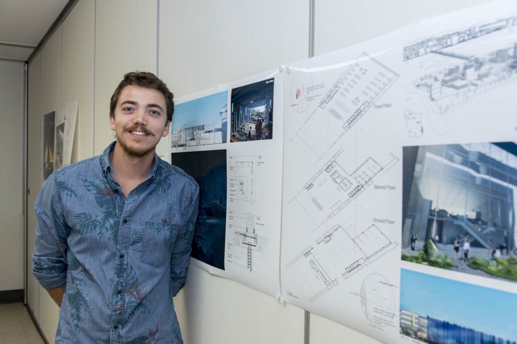 Student Matthew Bople standing in front of architecture designs