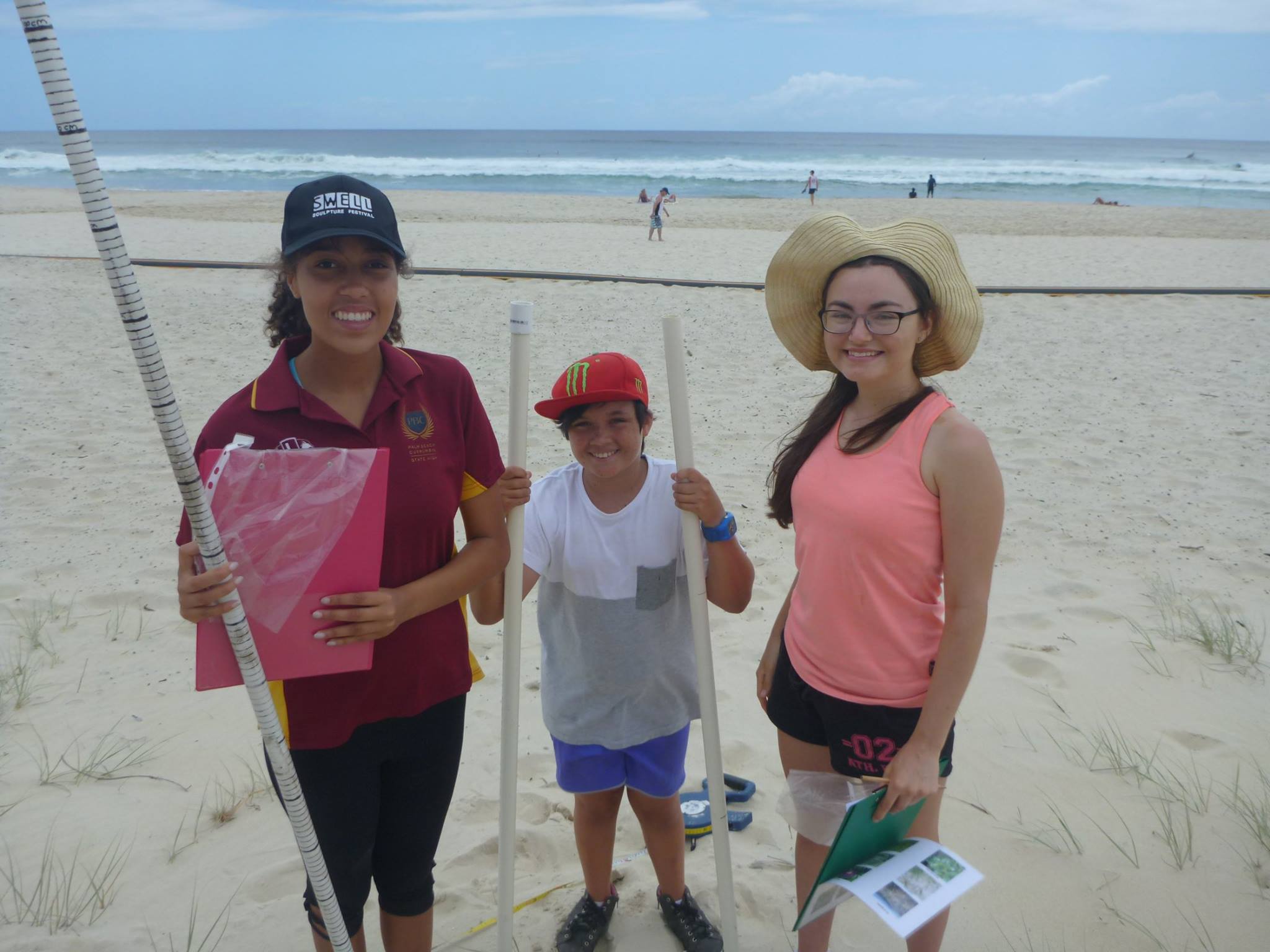 Three young on the beach checking the health of the dunes for Griffith Centre for Coastal Management DuneWatch program