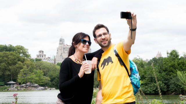 A couple taking a selfie in front of a tourist destination.