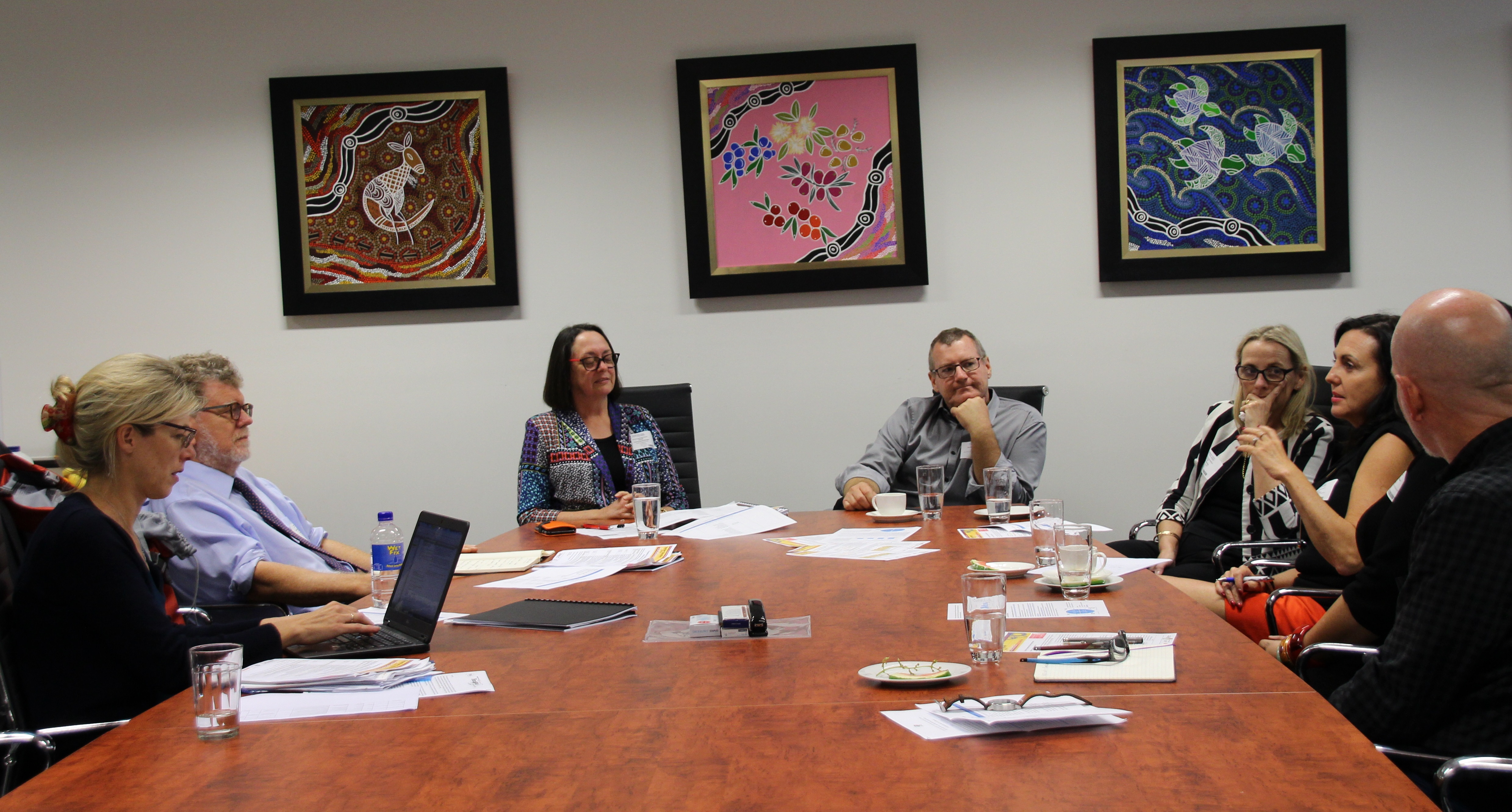 Professional staff from Griffith and OECD around a boardroom table in discussion