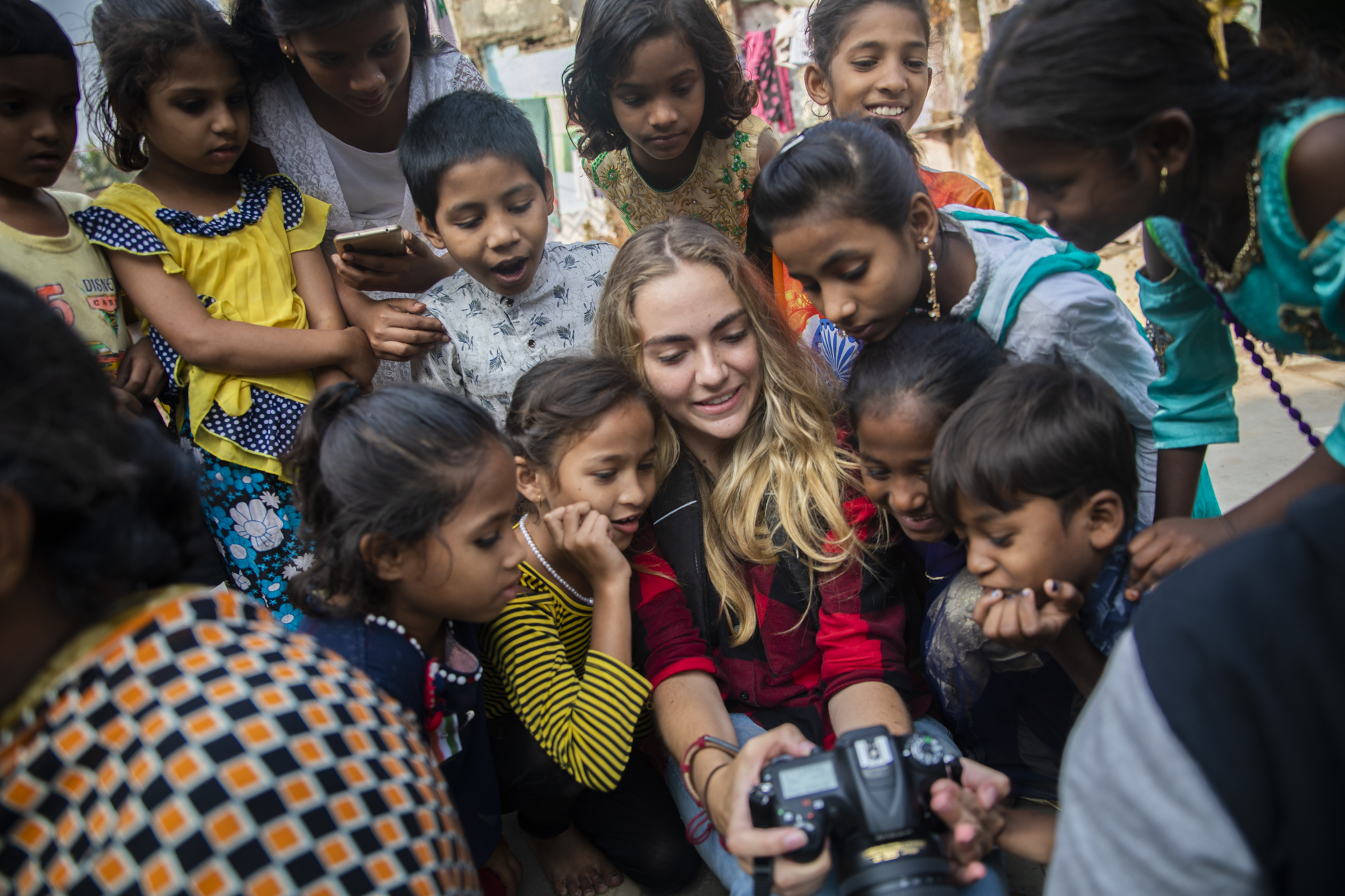 Journalism student Marena Jansevanrensburg shows Mumbai children photos on her camera. Photo: Dylan Crawford
