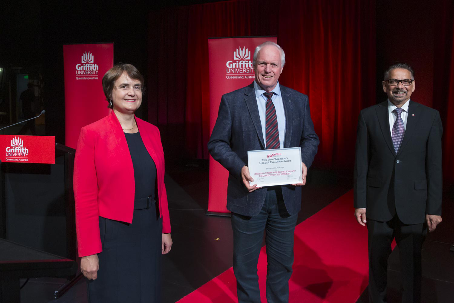 Professor David Lloyd accepts the Research Excellence Award for the Griffith Centre for Biomedical and Rehabilitation Engineering Menzies Health Institute Queensland from Vice Chancellor and President Professor Carolyn Evans and Deputy Vice Chancellor (Research) Professor Mario Pinto.