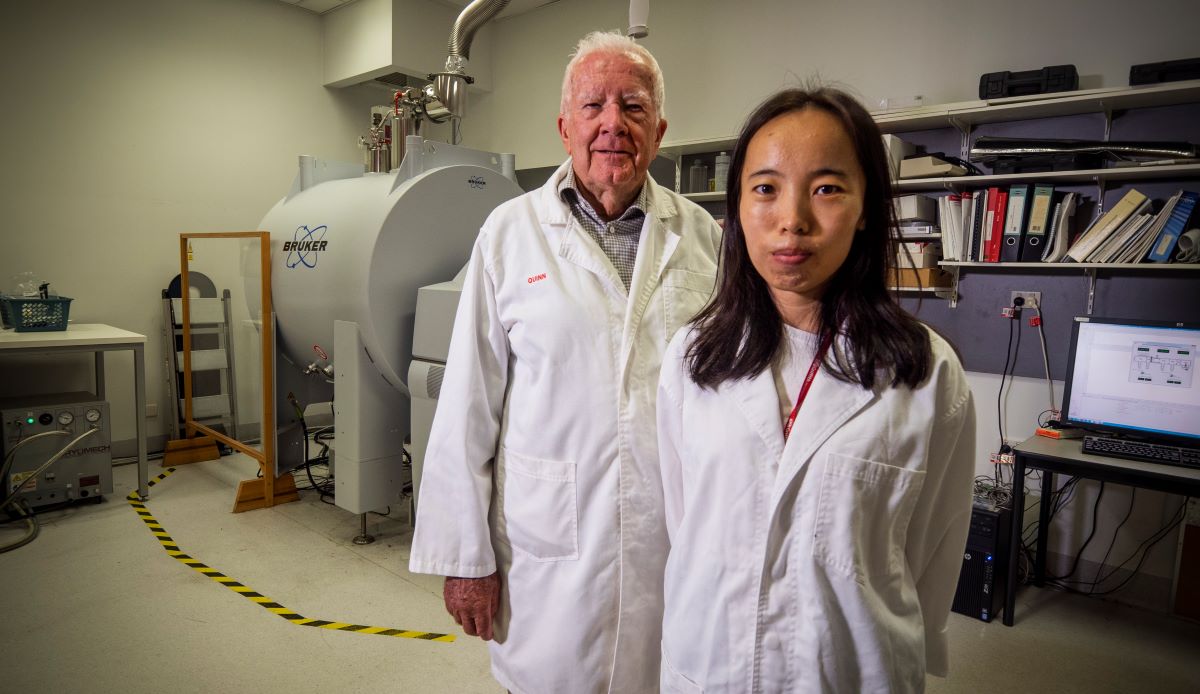 Professor Ron Quinn AM and Dr Miaomiao Liu next to the Mass Spectrometer used in their research.
