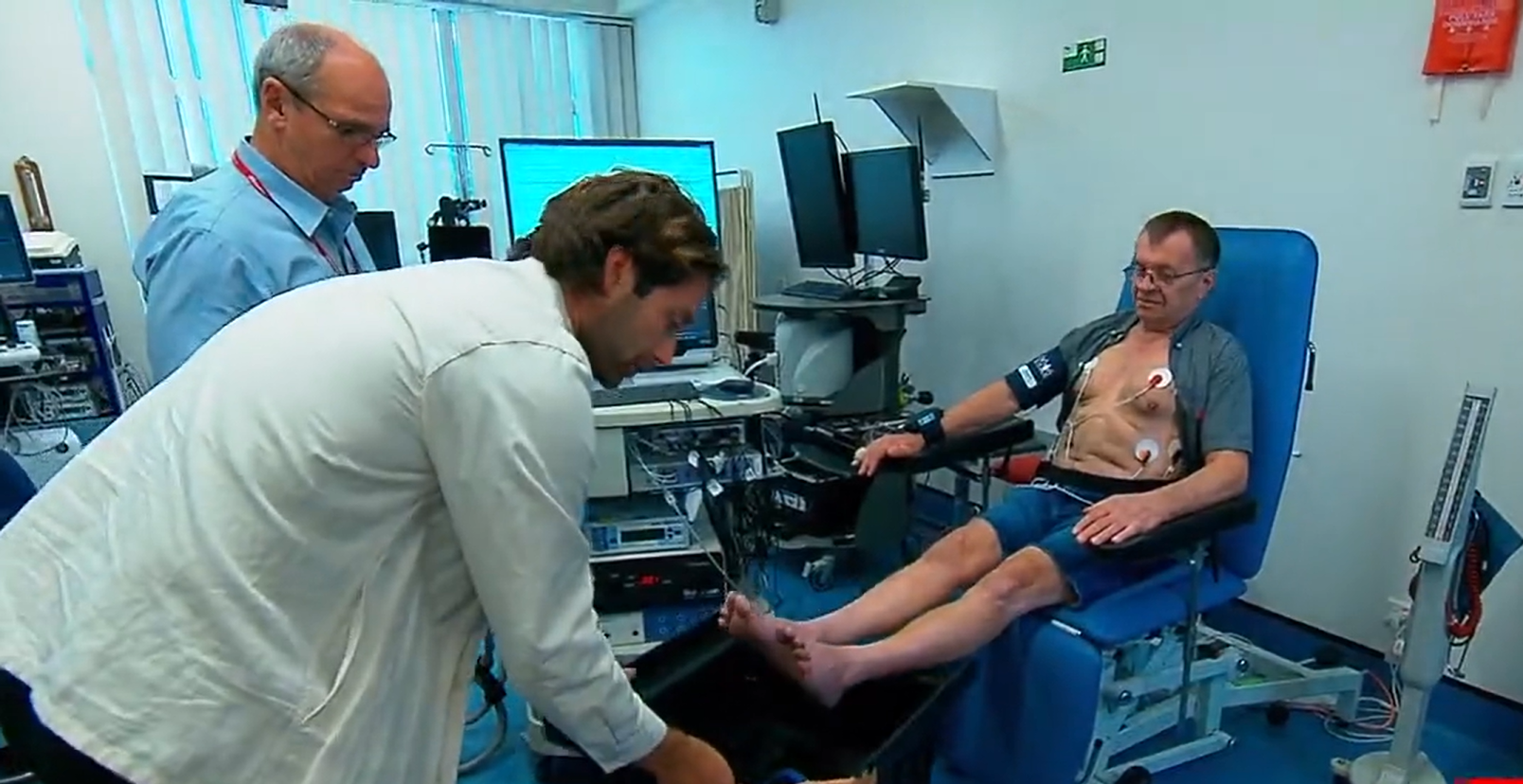 Dr Fergus O'Connor and Professor Norman Morris helping a heart failure patient submerse their legs in warm water